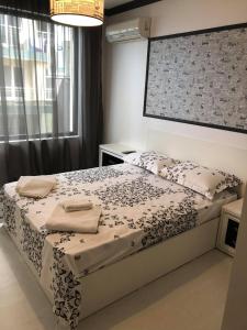 um quarto com uma cama e uma grande janela em Апартамент Анели em Pomorie
