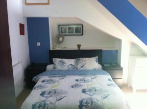 Schlafzimmer mit einem Bett mit blauer und weißer Bettwäsche in der Unterkunft Hotel de Savoie in Annecy