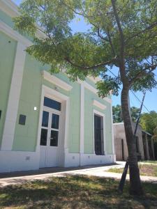 un bâtiment vert avec un arbre en face dans l'établissement La Casa del Molino, à Ramallo
