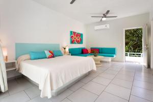 a bedroom with a large bed and a blue couch at AzulPitaya Beach Front Hotel in Sayulita in Sayulita