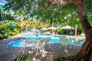 a group of tables and chairs next to a pool at AzulPitaya Beach Front Hotel in Sayulita in Sayulita