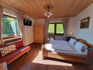 a bedroom with a large bed and a couch at Apartments Teglbauernhof, Hütte, Chalet, Mobilheim, Appartement, Ferienwohnung, Pension, Urlaub in Uttendorf