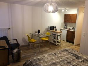eine Küche mit einem Tisch und gelben Stühlen in einem Zimmer in der Unterkunft Le Cerf, magnifique studio avec jardin-terrasse et garage in Evolène