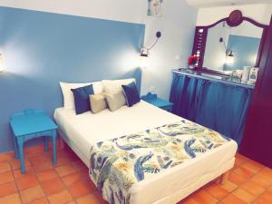 una camera con un grande letto con una parete blu di Résidence de la baie - BLEU SOLEIL TARTANE a La Trinité