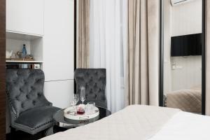 sypialnia z łóżkiem, krzesłem i stołem w obiekcie Salomea Krakow apartments w Krakowie