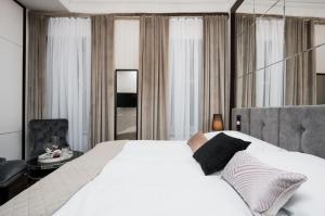 sypialnia z dużym białym łóżkiem i krzesłem w obiekcie Salomea Krakow apartments w Krakowie
