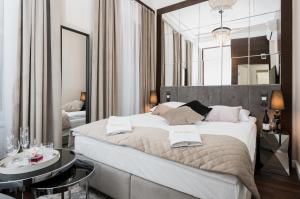 sypialnia z dużym łóżkiem z dwoma stołami w obiekcie Salomea Krakow apartments w Krakowie