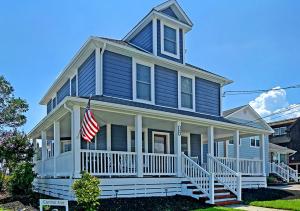 a blue house with an american flag on the porch at Stylish house one block to beach with linens and parking in Point Pleasant Beach