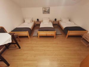 two beds in a room with wooden floors at Baka Ljuba 