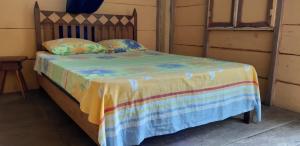 a bed with a colorful blanket and pillows on it at Centro Ecoturistico Ya´ajche in Lacanjá