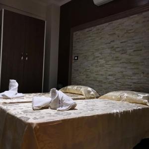 Guest House Bracciano RM في براتشيانو: غرفة نوم بسريرين مع شراشف ومناشف بيضاء