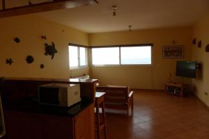 a living room with a microwave and a tv at Calheta - Casa Amarela in Calheta