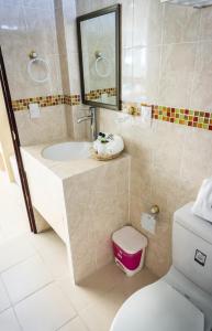 een badkamer met een wastafel, een toilet en een spiegel bij HOTEL DE LA PEÑA INN in Santo Domingo Tehuantepec