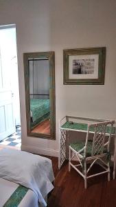 ein Schlafzimmer mit einem Spiegel, einem Stuhl und einem Bett in der Unterkunft Casa Chacabuco Tandil in Tandil