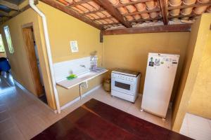 uma pequena cozinha com um frigorífico e um lavatório em Canyons Camping Capitolio em Capitólio