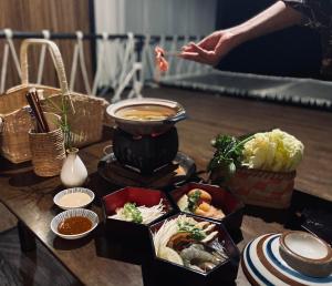 una mesa con tazones de comida y un tazón de sopa en Tanoshi Glamping In Khao Sok en Khao Sok