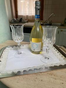 a bottle of wine sitting on a tray with two wine glasses at Appartamento B&B Orizzonti in Porto SantʼElpidio