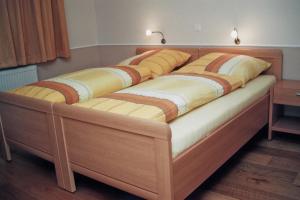 a large wooden bed with two covers on it at Hotel Franke in Alstätte