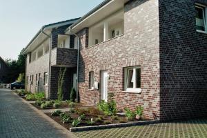 een rood bakstenen gebouw met planten aan de zijkant bij Hotel Franke in Alstätte