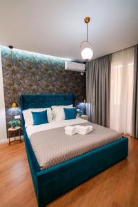 a bedroom with a blue bed with a blue headboard at Rama's Hotel in Tirana