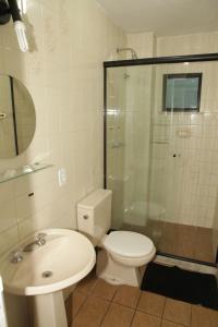 a bathroom with a toilet and a sink and a shower at Stratus Centro Hotel in Volta Redonda