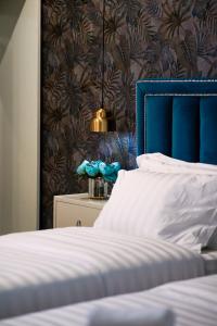 um quarto com uma cama com uma cabeceira azul em Rama's Hotel em Tirana