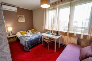 Mały pokój z łóżkiem i biurkiem z laptopem w obiekcie Villa Kava w Warszawie