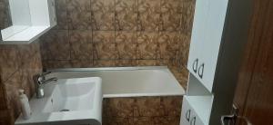 een kleine badkamer met een wastafel en een bad bij Apartament Luna in Mangalia