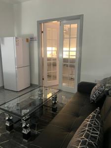 - un salon avec une table basse en verre et un réfrigérateur dans l'établissement Travis House Three Luxury Modern Living free WiFi, à Burnley