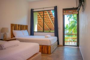 a bedroom with two beds and a large window at Lagarza Hostel in La Libertad