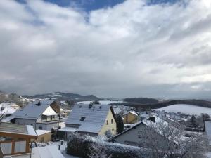 a snow covered city with houses and a lake at Am Belz in Lebach