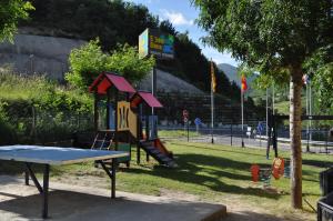 a playground with a slide and a table at Camping El Jabalí Blanco in Fiscal