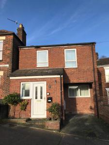 a red brick house with a white door at Cosy house, 3 bedrooms, private parking, wifi, patio in Norwich