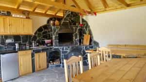 a kitchen and dining room with a stone fireplace at Pokoje Gościnne Tyrol in Zawoja