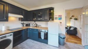 uma cozinha com armários azuis, um lavatório e uma máquina de lavar louça em Stunning 3-Bed house in Chester by 53 Degrees Property, ideal for Contractors & Families, FREE Parking - Sleeps 7 em Chester