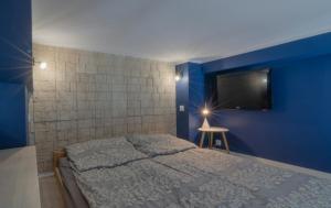 a bedroom with a bed and a blue wall at Holiday Home SLAVIA NEW 012 in Międzyzdroje