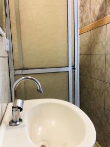a white sink in a bathroom with a shower at Casa Ilha do Mel in Ilha do Mel