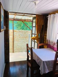 a dining room with a table and a large window at Casa Ilha do Mel in Ilha do Mel