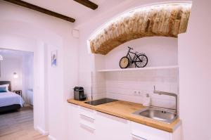 a kitchen with a sink and a bike on the wall at Chic Central Studio in Sibiu +24 photos