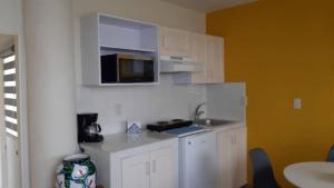 eine kleine Küche mit einer Spüle und einer Mikrowelle in der Unterkunft departamento paraiso estrella Raquet Club in San Juan Cosalá
