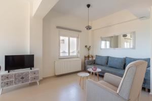 a living room with a blue couch and a tv at Plaka apt Homeleader in Plaka