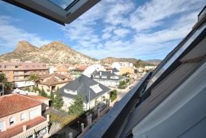 una ventana con vistas a una ciudad con montañas en Hotel Hyltor, en Archena