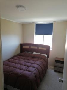 1 dormitorio con cama morada en una habitación con ventana en DEPTO LAGUNA BAHIA MARINA, en Algarrobo