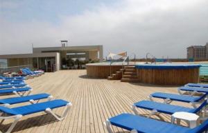 a group of blue lounge chairs sitting on a beach at DEPTO LAGUNA BAHIA MARINA in Algarrobo