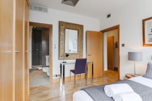 ein Schlafzimmer mit einem Bett und einem Schreibtisch sowie ein Badezimmer in der Unterkunft StayInn Monument in London