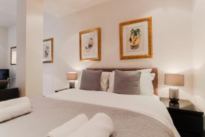 a bedroom with a large white bed with two lamps at Monument by Excel Apartments in London