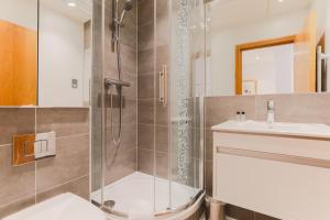 a bathroom with a shower and a toilet and a sink at Monument by Excel Apartments in London +70 photos