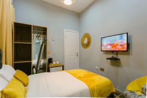 Un pat sau paturi într-o cameră la The Avery Suites, East Legon