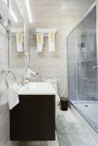 阿克拉The Avery Suites, East Legon的一间带水槽、淋浴和卫生间的浴室 更多37张照片