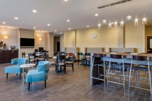 a restaurant with blue chairs and tables and a bar at MainStay Suites Great Falls Airport in Great Falls